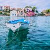 White fishing boat in the blue rippled sea water bay in Assos village, Kefalonia island, Greece.